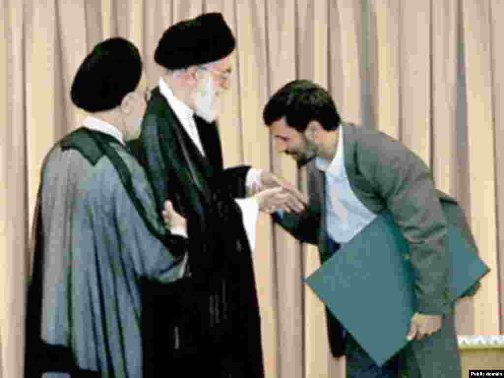 İranın prezidenti Mahmud Ahmadinejad bu ölkənin ali dini lideri Ayatollah Ali Khamenei-nin əli öpür. 2005-ci il.&nbsp;