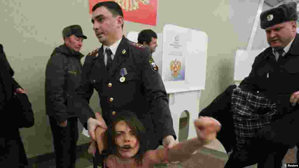 FEMEN qrupunun aktivisti se&ccedil;ki məntəqəsində etiraza cəht edərkən