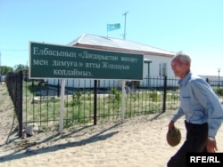 Ауылдық әкімдік кеңсесі алдынан өтіп бара жатқан адам. Мақат ауданы, Атырау облысы, шілде, 2009 жыл. Көрнекі сурет.