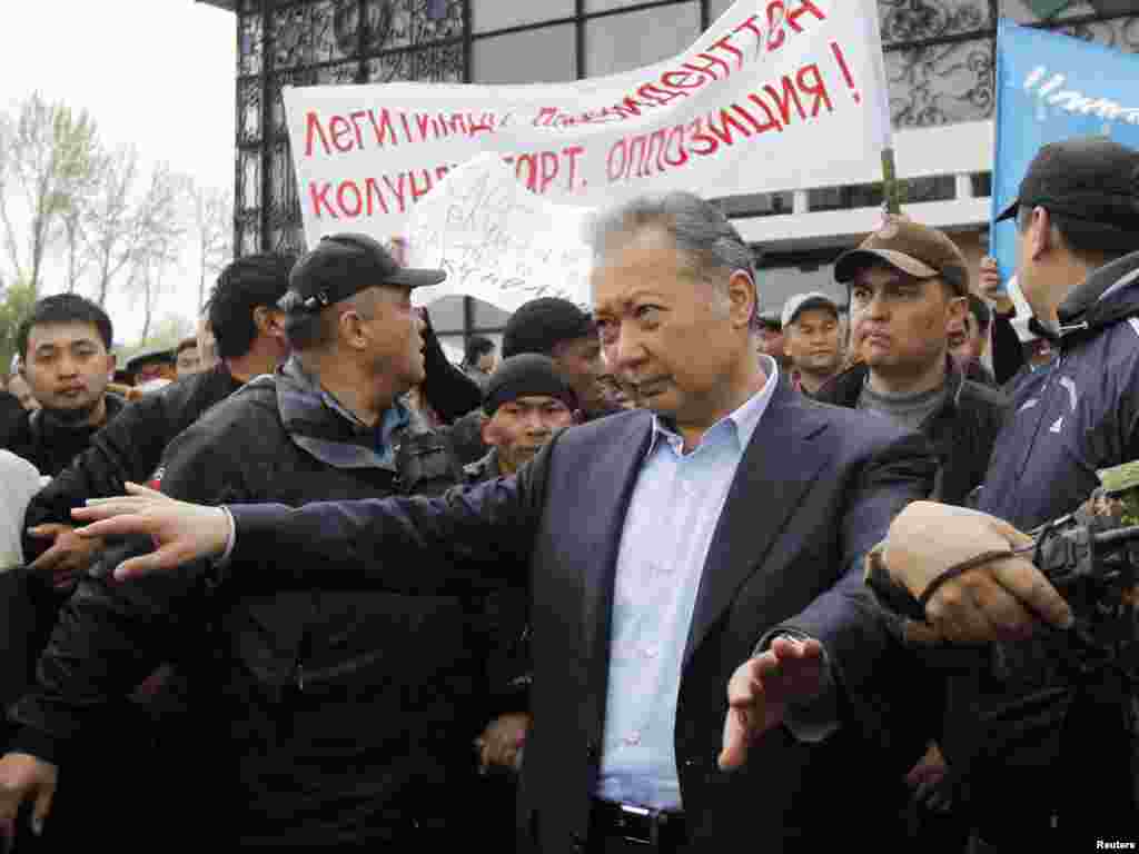 Оққағарлар уақытша үкіметті қолдаушылардың шабуылынан кейін Бакиевтің митингіден шығып кетуіне көмектесіп жатыр. Ош, 15 сәуір 2010 жыл.