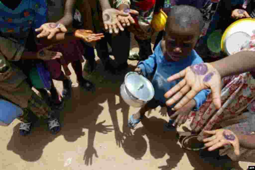 IVORY COAST -- Bouaké : Ivorian children show the hand stamps entitling them to food handouts at a feeding center in Bouake 28Feb2003