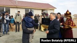 Ақмола облысының әкімі Сергей Кулагин су тасқынынан зардап шеккен Оразақ ауылының тұрғындарына жаңа пәтер кілттерін табыстап тұр. Ақмола облысы, 15 қыркүйек 2015 жыл.